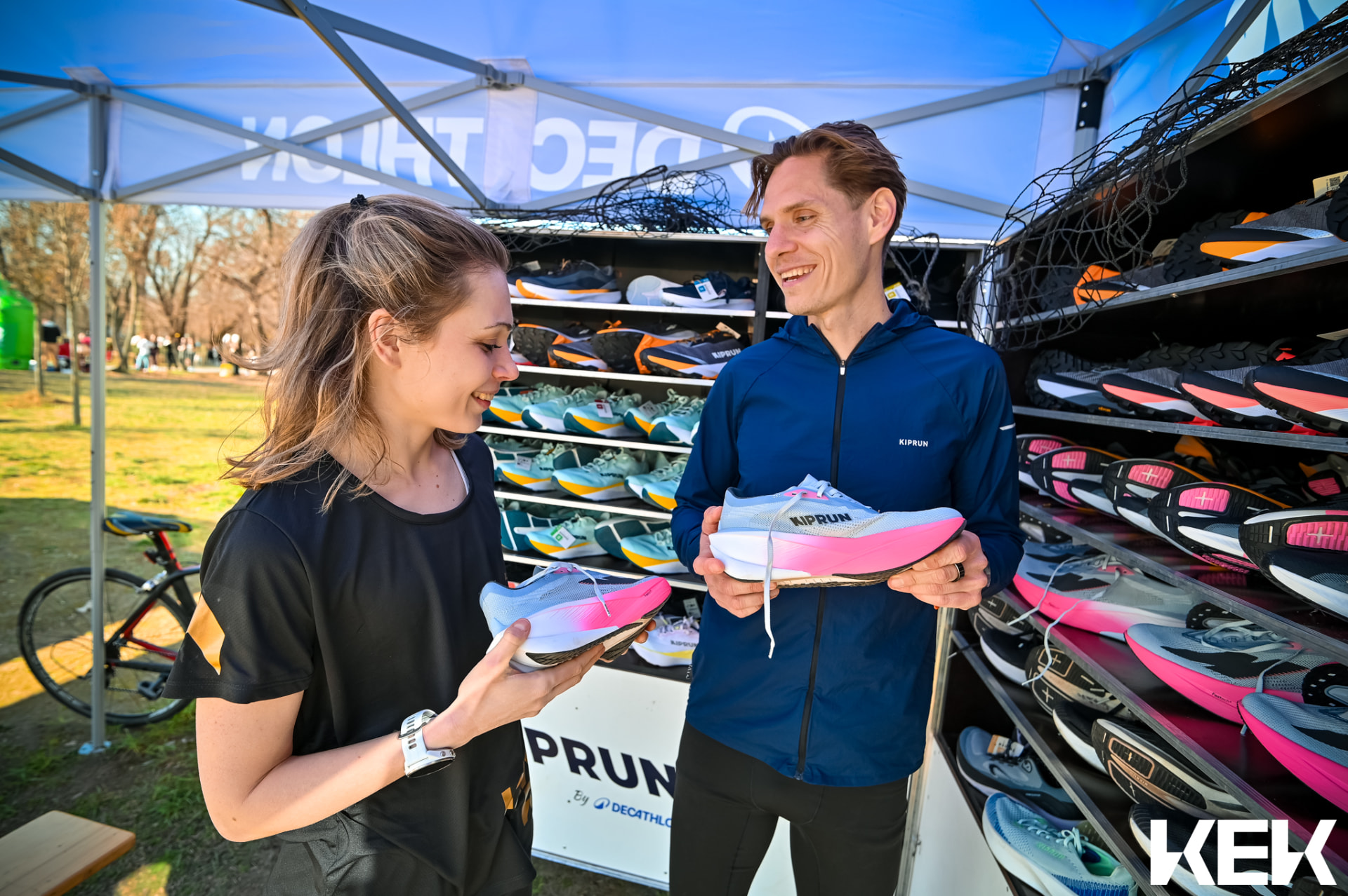 Julienn and Berci comparing Kiprun racing shoes at a Decathlon running event tent